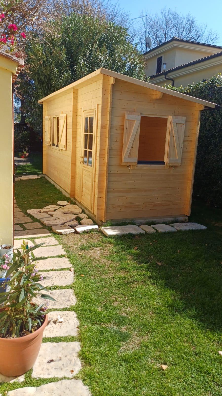 Casetta in legno con persiane artigianali e camminamento in pietra