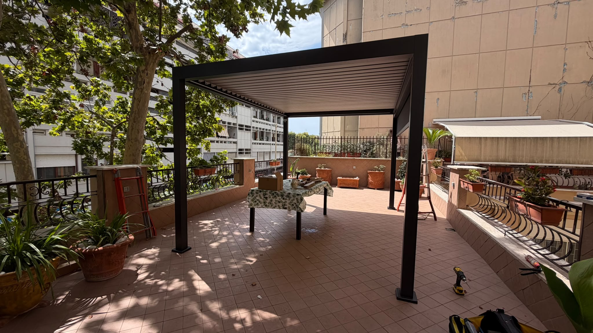 Pergola bioclimatica antracite con lamelle orientabili su ampio terrazzo